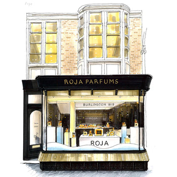 Illustration of a perfume shop with a black and gold sign reading “Roja Parfums” above a large display window showcasing perfume bottles. The building has tall windows and a brick façade.
