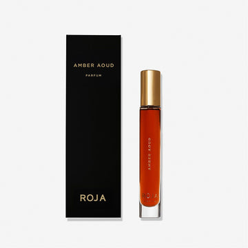 A bottle of Roja Parfums Amber Aoud (100% off) stands beside its elegant black and gold box on a white background. Enjoy a Free Gift BOGO Bundle with this luxurious scent exclusively at BOGOS.io.