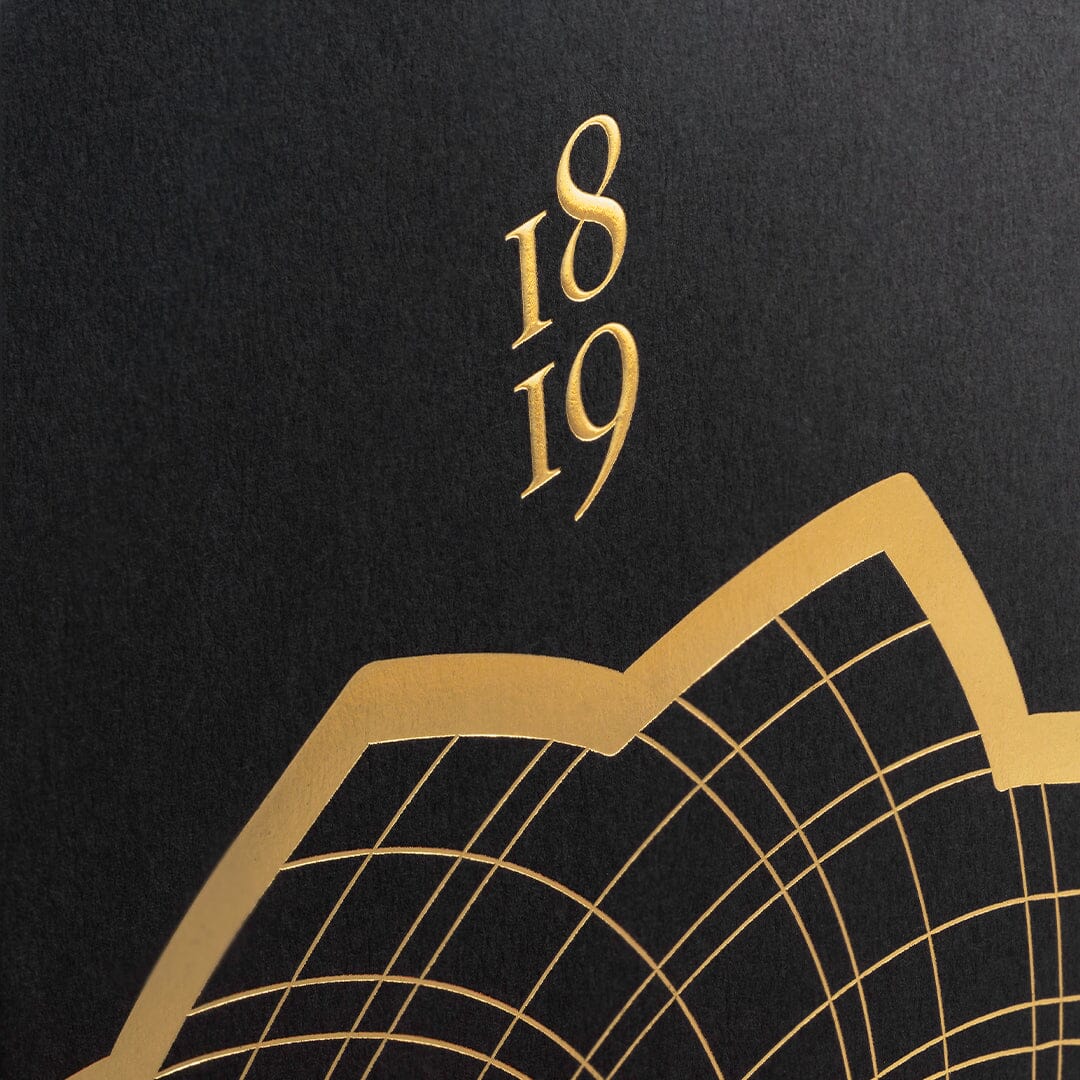 Gold numbers 1819 and a geometric pattern are embossed on a black background, reflecting the luxury of Roja Parfums Burlington 1819. The design features curved and straight gold lines, seen partially in the lower right corner.