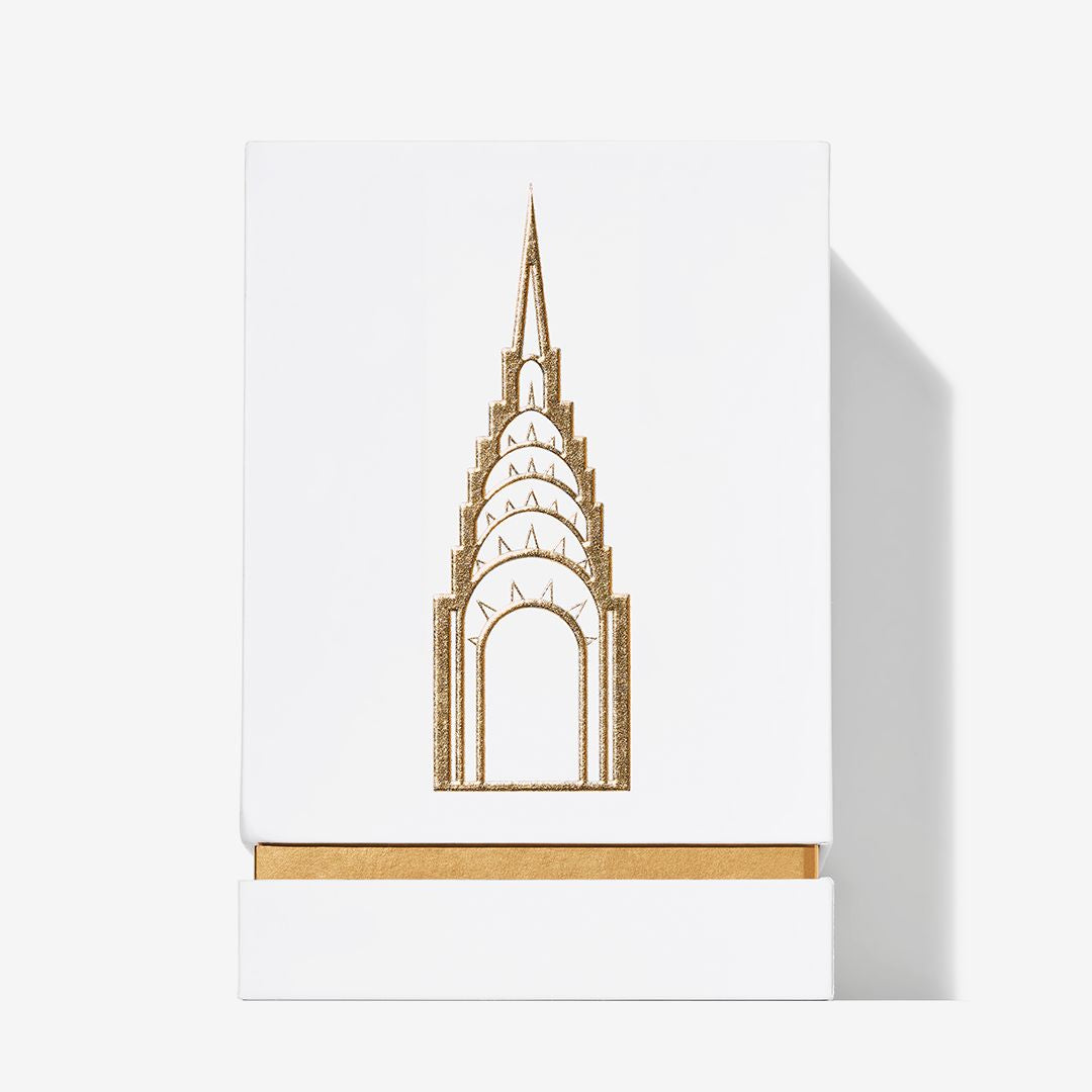 A white box with a gold outline of the Chrysler Building and matching gold accents evokes the refined spirit of Roja Parfums’ Manhattan Eau De Parfum, featuring notes of cedarwood and tobacco.