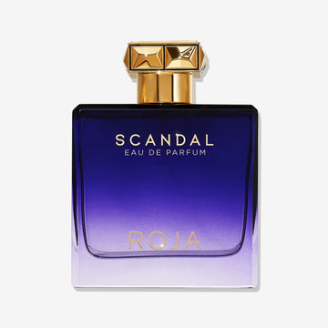 A rectangular perfume bottle with a gold cap features a gradient from deep purple to light lavender, gold Scandal Pour Homme lettering, and holds ROJA Parfums modern Fougère cologne for men.