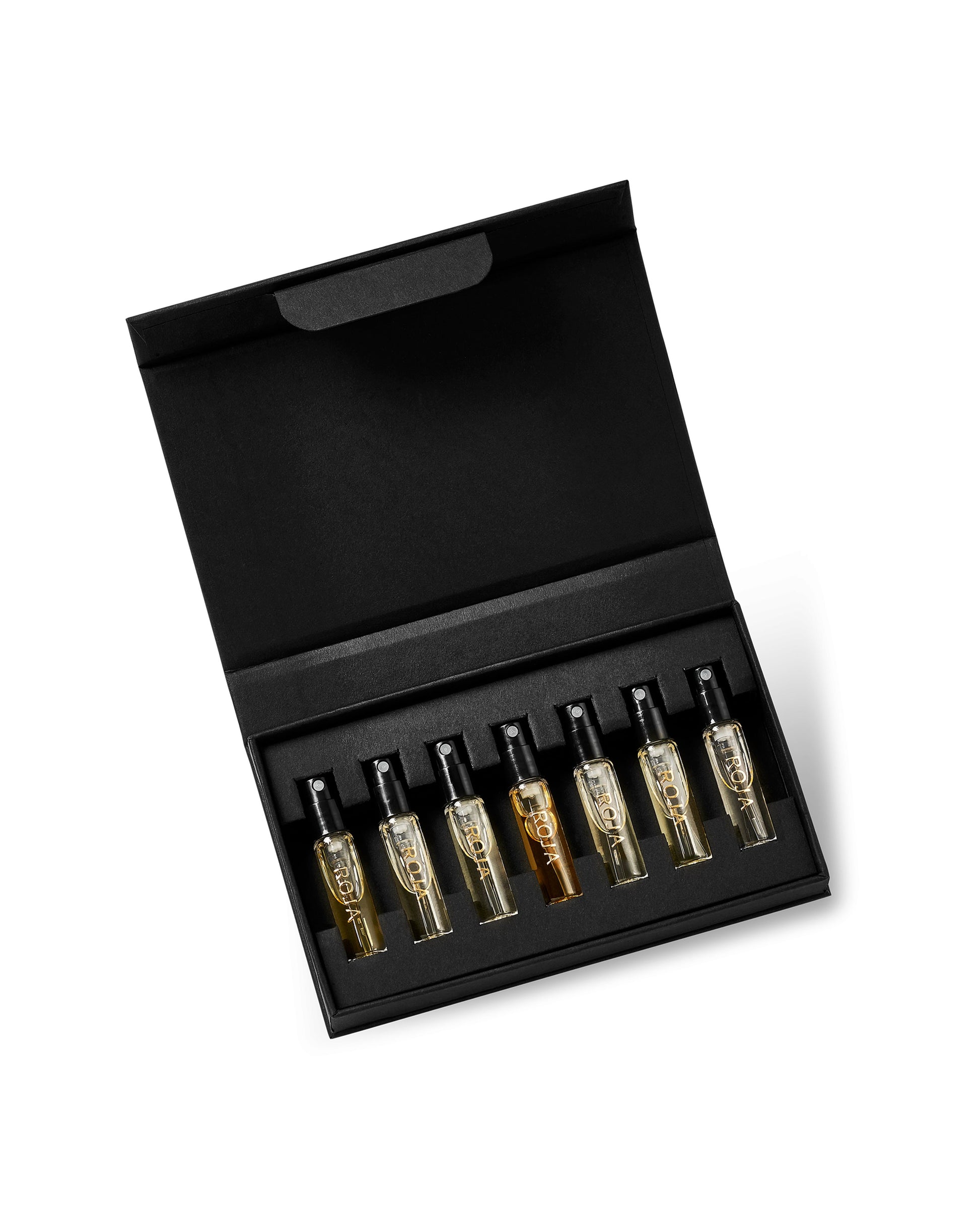 The Mens Discovery Collection by Roja Parfums features eight colored fragrance glass ampoules with dropper tops, arranged in a sleek black box set and displayed against a white background.