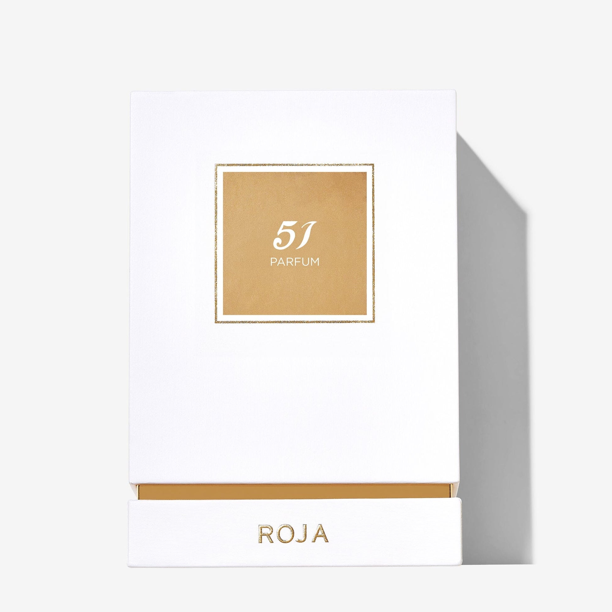 A white rectangular box of Roja Parfums 51 Pour Femme features a gold square label with 51 PARFUM and ROJA in gold at the bottom, casting a shadow on a light background.
