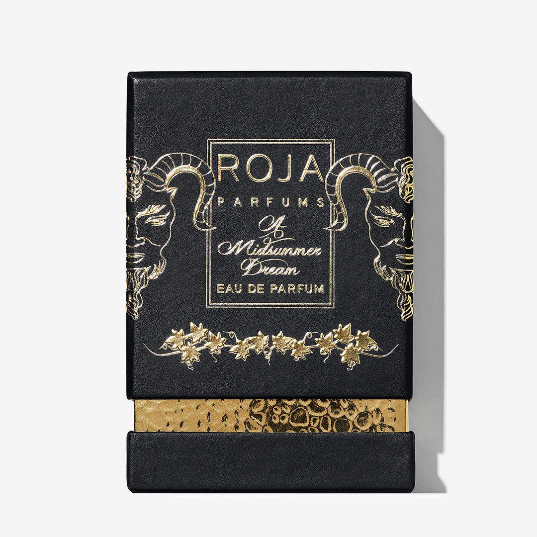 A black and gold Roja Parfums box for A Midsummer Dream displays ornate ram head art, floral details, a gold textured base, and the fragrance name—capturing an enchanting summer Chypré scent.