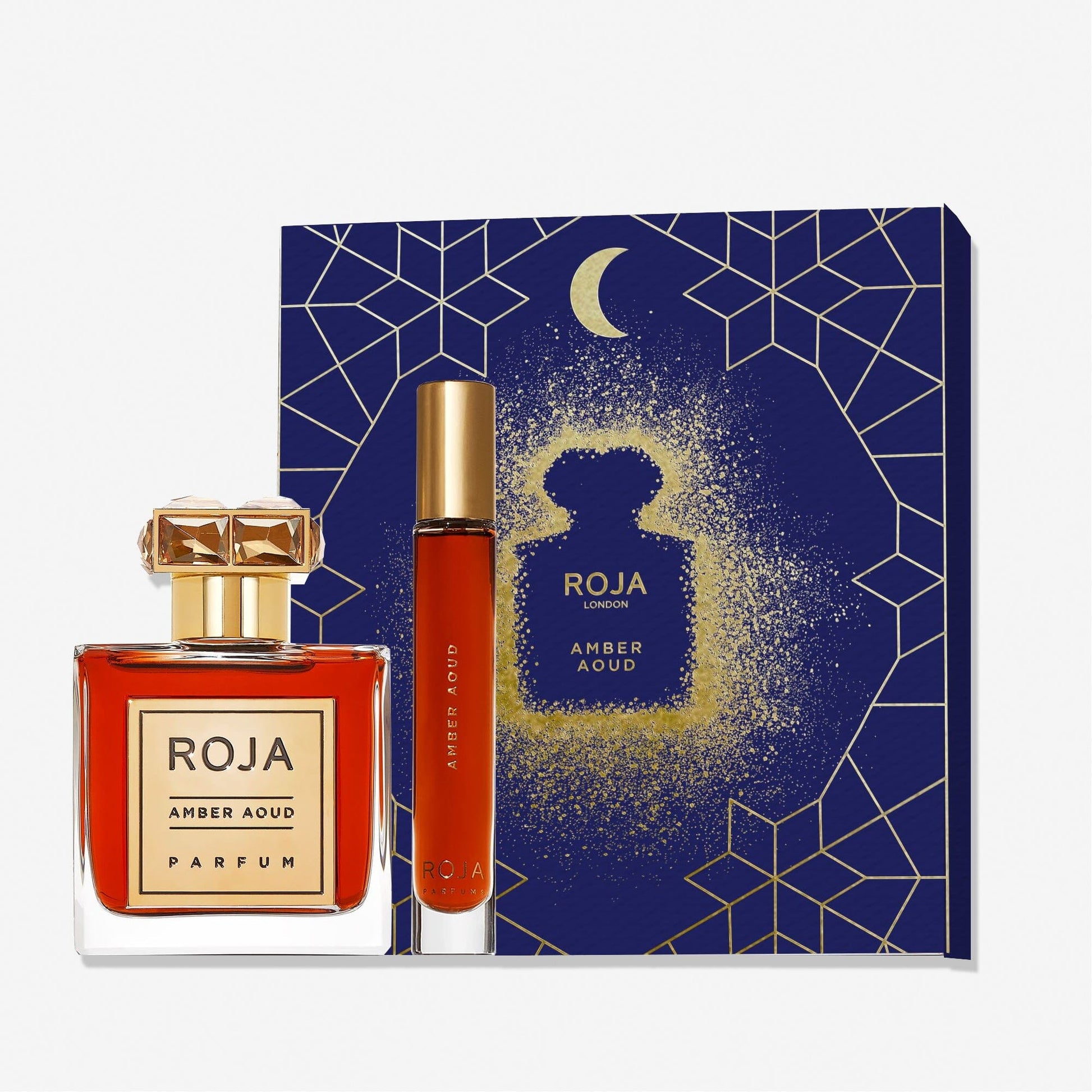 The Amber Aoud Eid Coffret by Roja Parfums is an ideal Eid gift, featuring a square fragrance bottle with gold cap, a slim spray vial, and a dark blue box decorated with gold geometric and moon motifs.