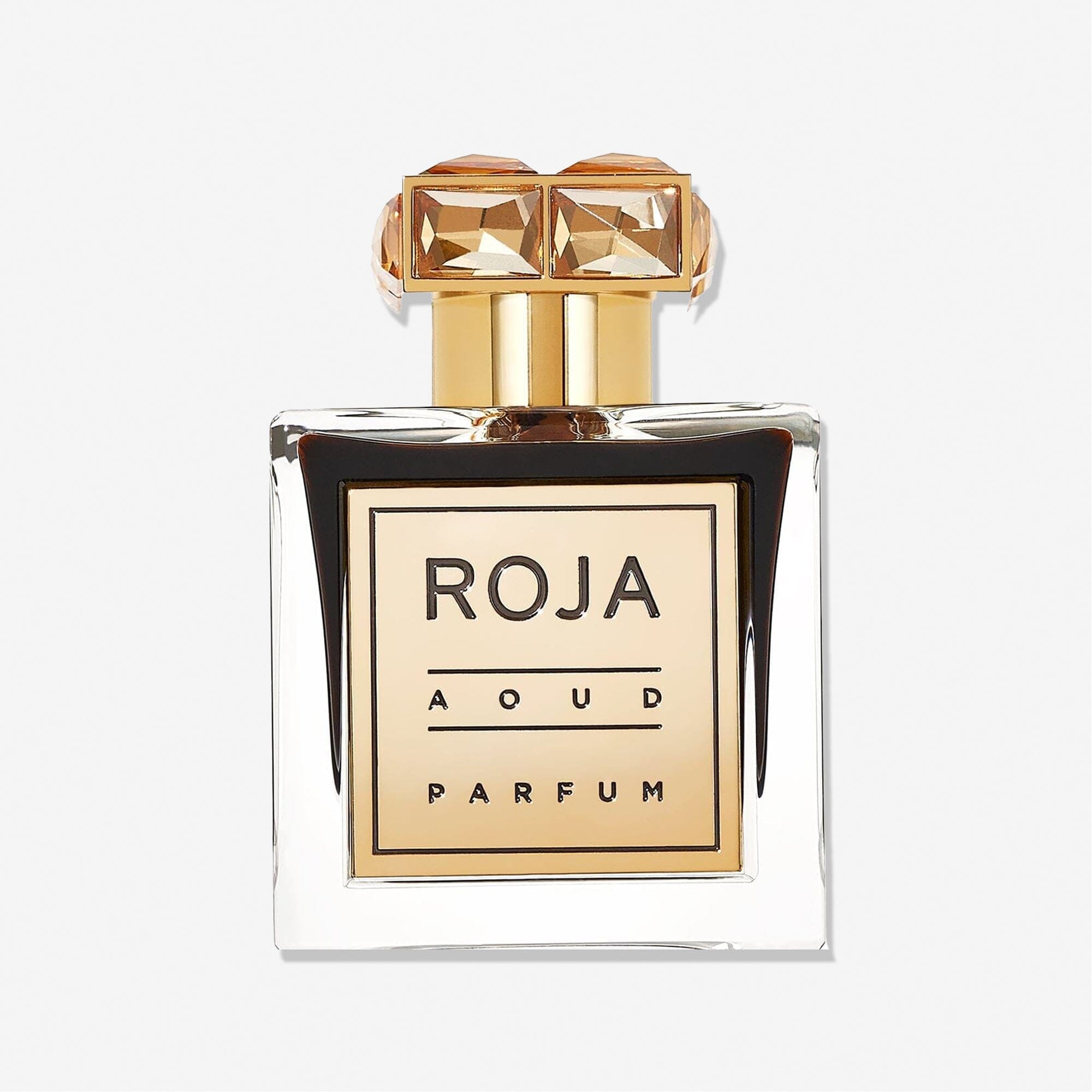 A clear glass bottle with a gold label reading Roja Parfums Aoud CRYSTAL™️ and a decorative gold geometric cap, set against a white background—capturing the essence of Rose Oud and saffron in every detail.