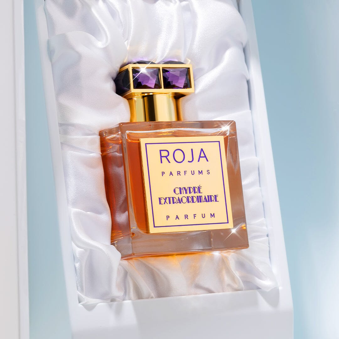 Chypré Extraordinaire by Roja Parfums, featuring a gold and purple cap, sits in a white satin-lined box and exudes a chic blend of Bergamot and Moss Notes.