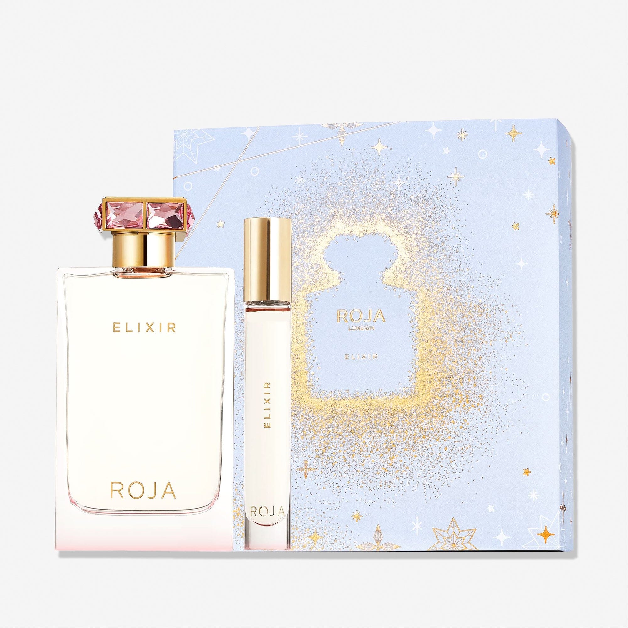 The Elixir Coffret by Roja Parfums features large and small bottles displayed before a decorative light blue gift box with gold sparkles and star patterns.
