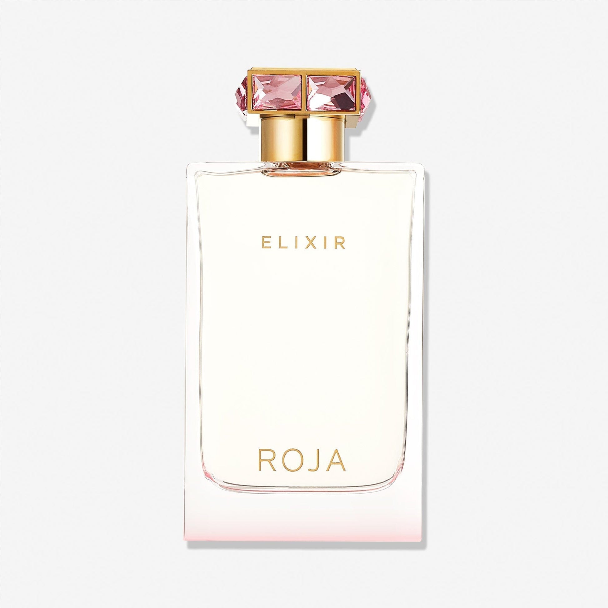 A clear perfume bottle with gold accents, labeled "Elixir Pour Femme" at the top and "Roja Parfums" at the bottom. The jewel-studded gold cap features large pink gemstones, highlighting this luxurious fragrance against a plain white background.