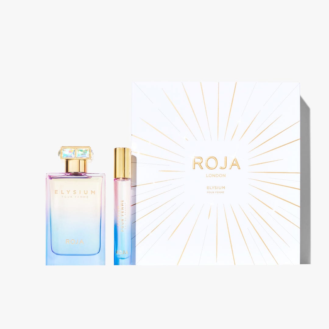The Elysium Pour Femme Festive Gift Set by Roja Parfums features a white and gold sunburst box, a large fruity floral Elysium perfume with musks, and a gradient blue-pink travel spray.