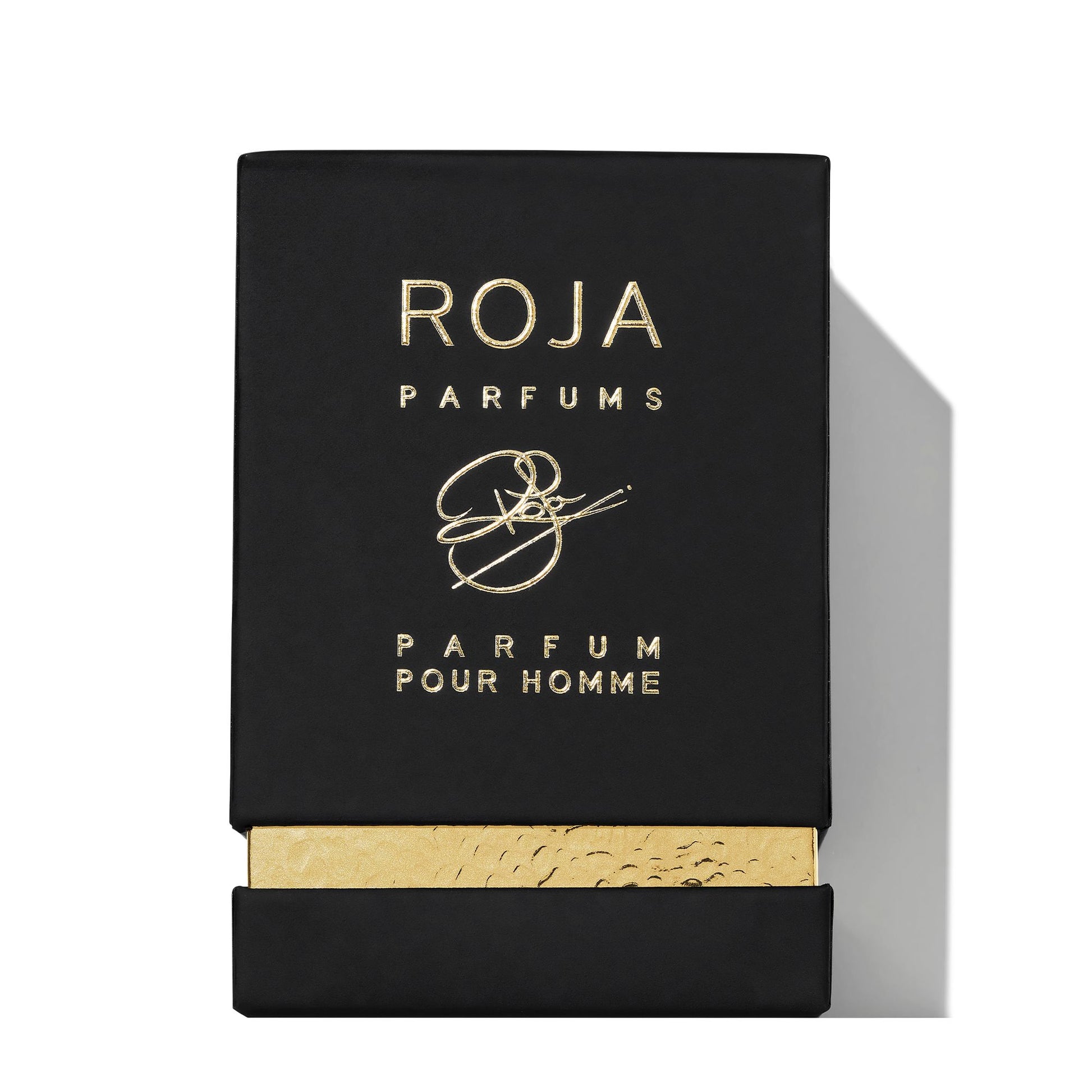 A black rectangular box with gold embossed Roja Parfums and Enigma Gift Set above a gold accent at the bottom. The partially opened box reveals a textured gold inner layer, making it a standout addition to any fragrance collection.