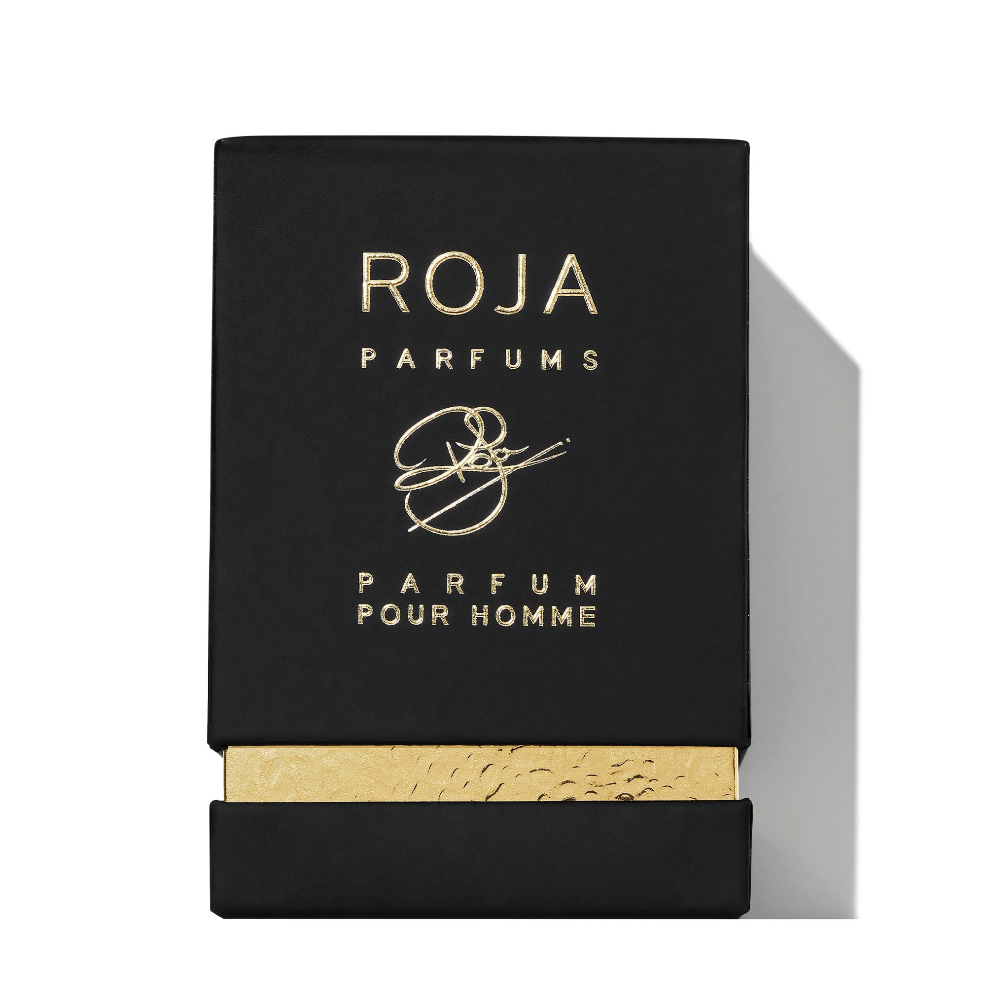 A black rectangular box with gold embossed Roja Parfums and Enigma Gift Set above a gold accent at the bottom. The partially opened box reveals a textured gold inner layer, making it a standout addition to any fragrance collection.