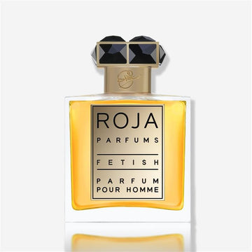 A rectangular bottle of Roja Parfums Fetish Pour Homme, featuring golden accents, a black geometric cap, and amber liquid, suggests a bold leather scent and is shown against a white background.