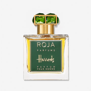 A glass bottle of Roja Parfums Harrods Pour Homme, a Harrods exclusive fragrance, features a green and gold label and a gold cap adorned with two green, gem-like squares.