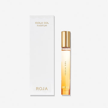 A slender bottle of Isola Sol by Roja Parfums with a gold cap stands beside its sleek white box, both adorned with minimalist gold lettering—capturing the essence of an island escape against a plain white background.