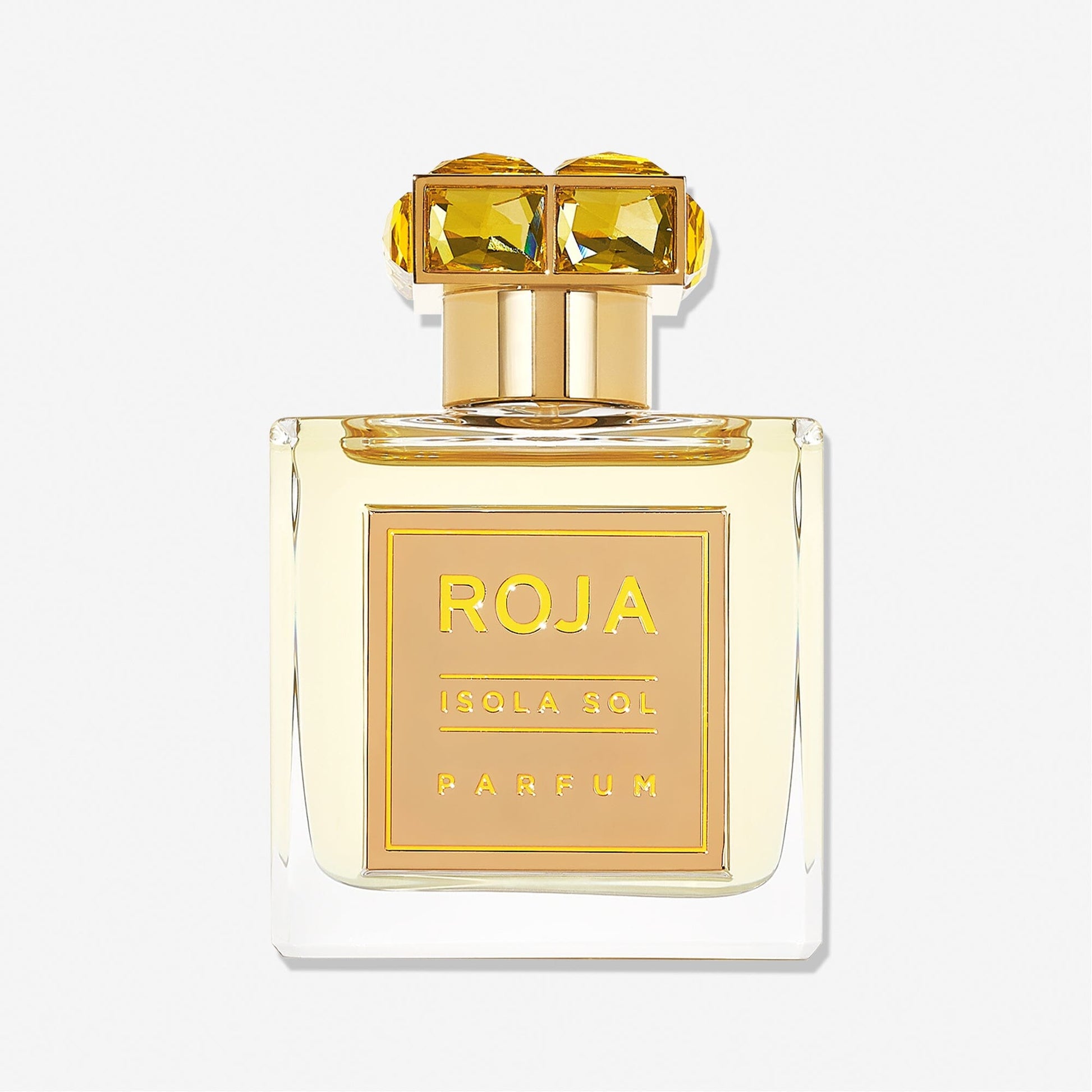 A clear glass perfume bottle labeled Isola Sol by Roja Parfums, topped with a gold cap featuring two large yellow gemstones, evokes island vacation vibes against a plain white background.