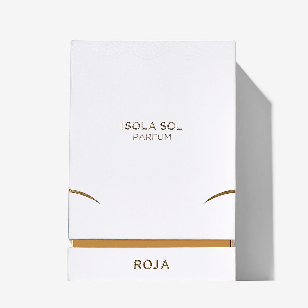 A white rectangular perfume box with gold accents evokes an island escape. ISOLA SOL is centered in gold, and Roja Parfums appears at the bottom on a pull-out drawer. The background is plain white.