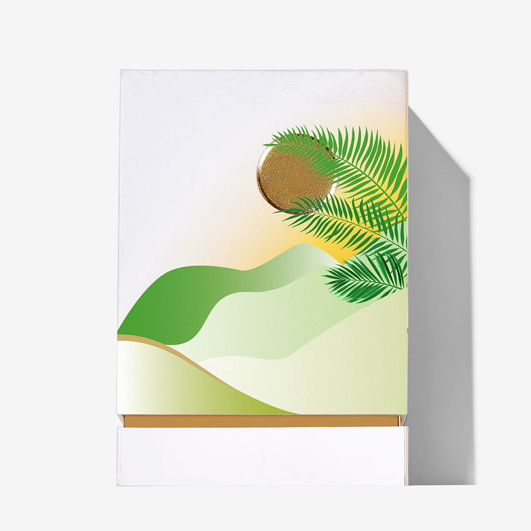 A minimalist box design with green hills, a gold sun, and palm leaves on white evokes the allure of Isola Verde by Roja Parfums—an exotic fragrance inspired by luxurious destinations.