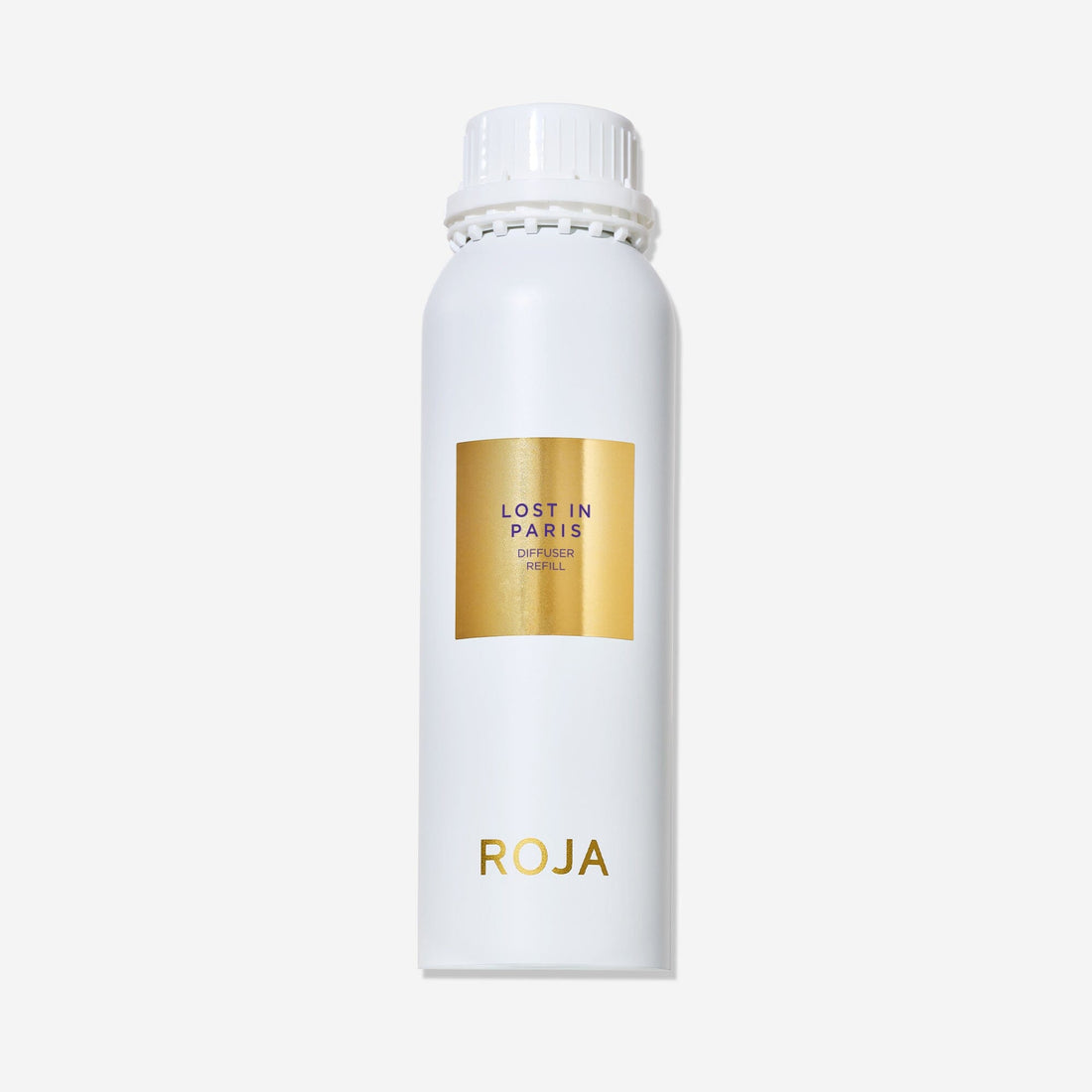 A white cylindrical bottle with a white cap displays a gold label reading Lost in Paris and ROJA London near the bottom. This ROJA London Lost in Paris diffuser captures a gourmand essence. The background is plain white.