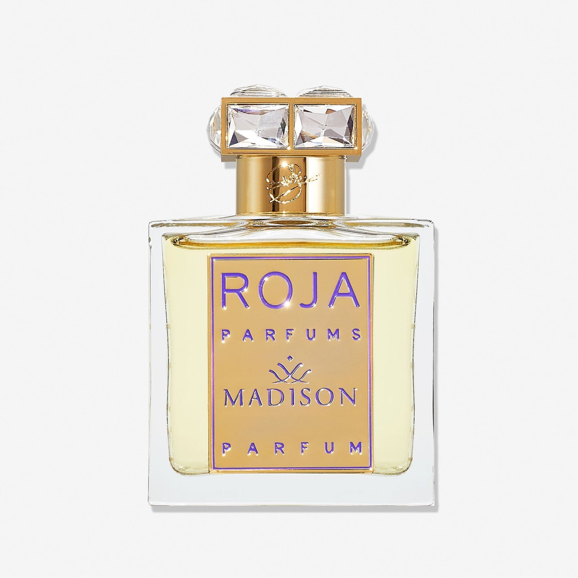 A clear glass bottle labeled Roja Parfums Madison Pour Femme features a gold and purple front plate and a cap adorned with two square, crystal-like gems, hinting at an elegant rose perfume with subtle notes of sandalwood.
