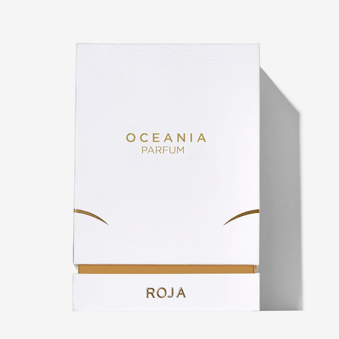 A white box with gold Oceania lettering from Roja Parfums stands out against a light background, its lower drawer section marked with the brand name and evoking a refreshing sea breeze.