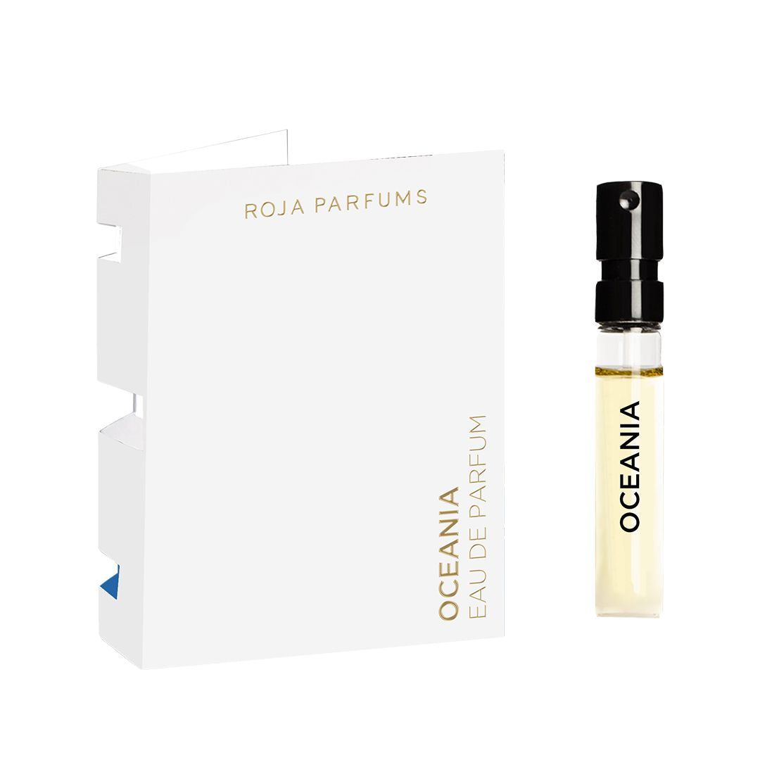A small spray vial labeled Oceania Sample sits beside a minimalist white card with gold text that reads Roja Parfums.