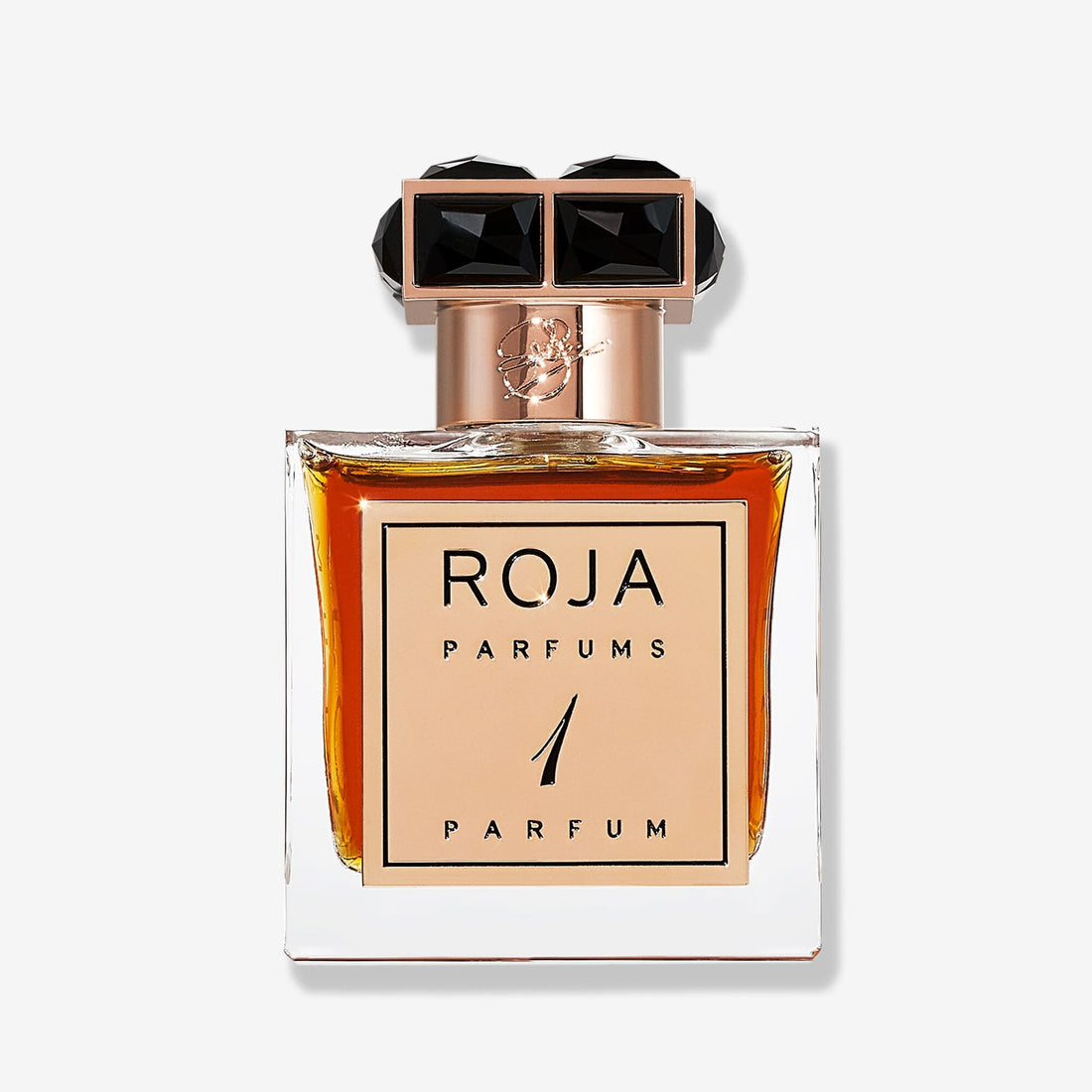 A rectangular, clear bottle of amber Parfum De La Nuit 1 by Roja Parfums features a gold neck and a bold black and gold geometric cap, with the name displayed in elegant gold and black lettering.