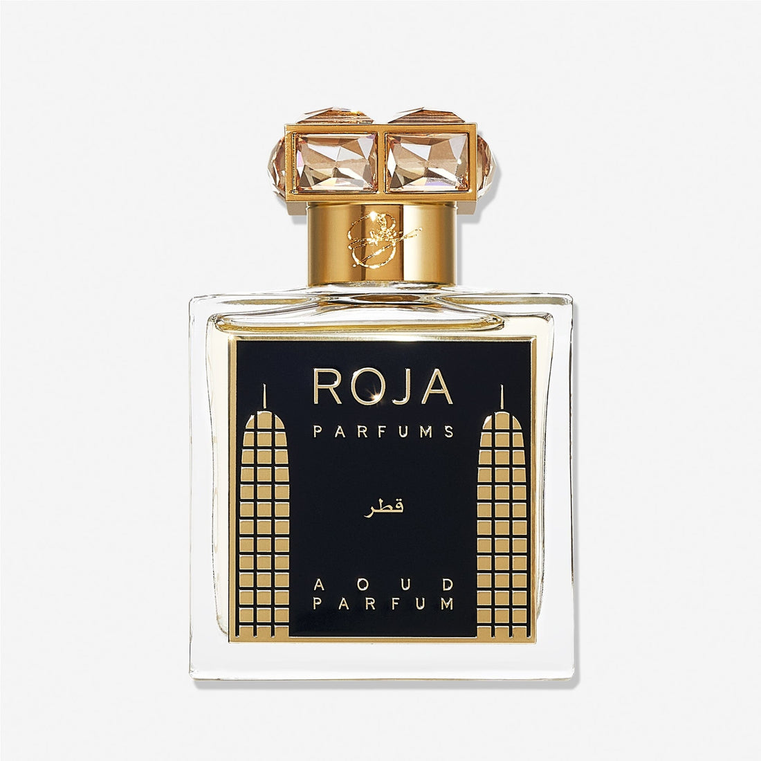 A luxury Roja Parfums Qatar perfume bottle features gold accents, geometric designs, and a crystal-studded gold cap—evoking notes of peach and pear in its lavish presentation.