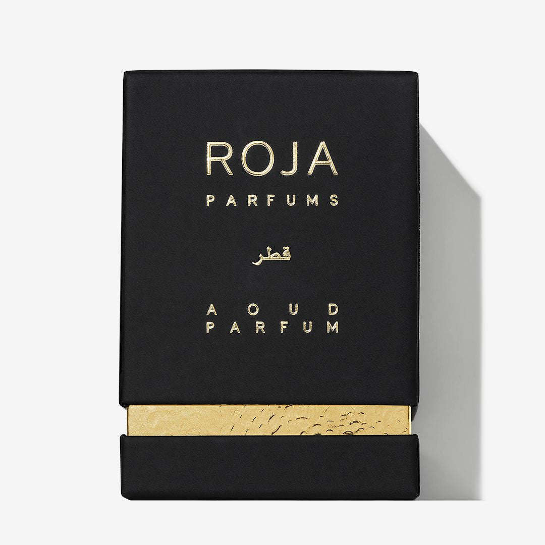 A black rectangular perfume box from Roja Parfums features gold accents, ROJA PARFUMS and SULTANATE OF OMAN on the front, with patterns evoking the oud and frankincense heritage of Oman.