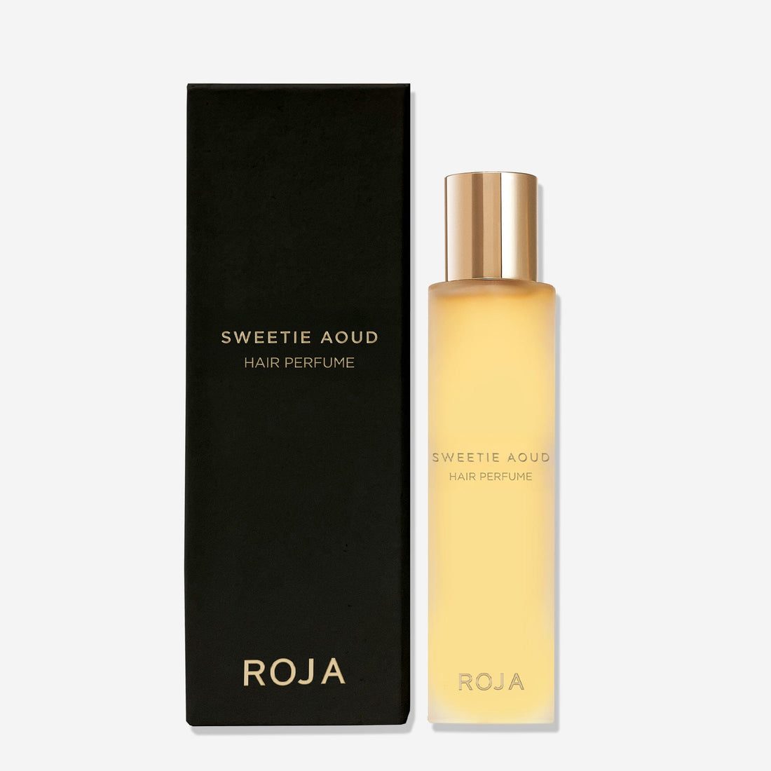 A matte black box labeled Sweetie Aoud Hair Perfume by Roja Parfums sits beside a frosted bottle with a gold cap and gold text, both on a plain white background—showcasing this luxurious gourmand perfume with rich agarwood notes.
