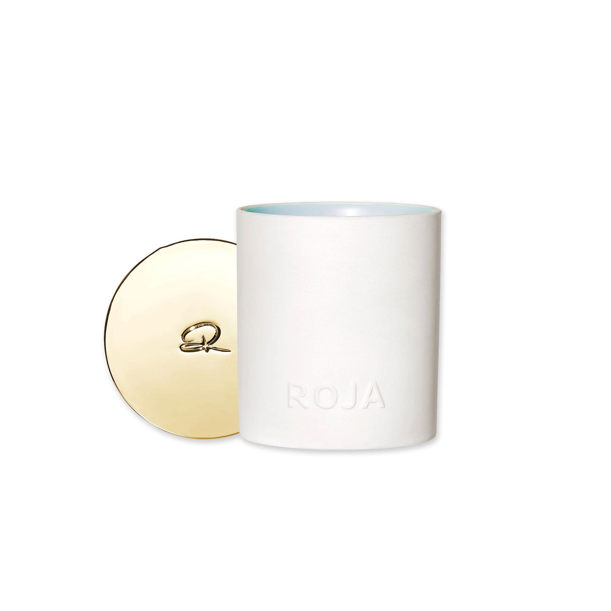 A white cylindrical candle holder by Roja Parfums, embossed with ROJA, sits beside its shiny gold lid with a signature motif—ideal for filling your space with the Jasmine Tea scent of Tea Time In The Conservatory.