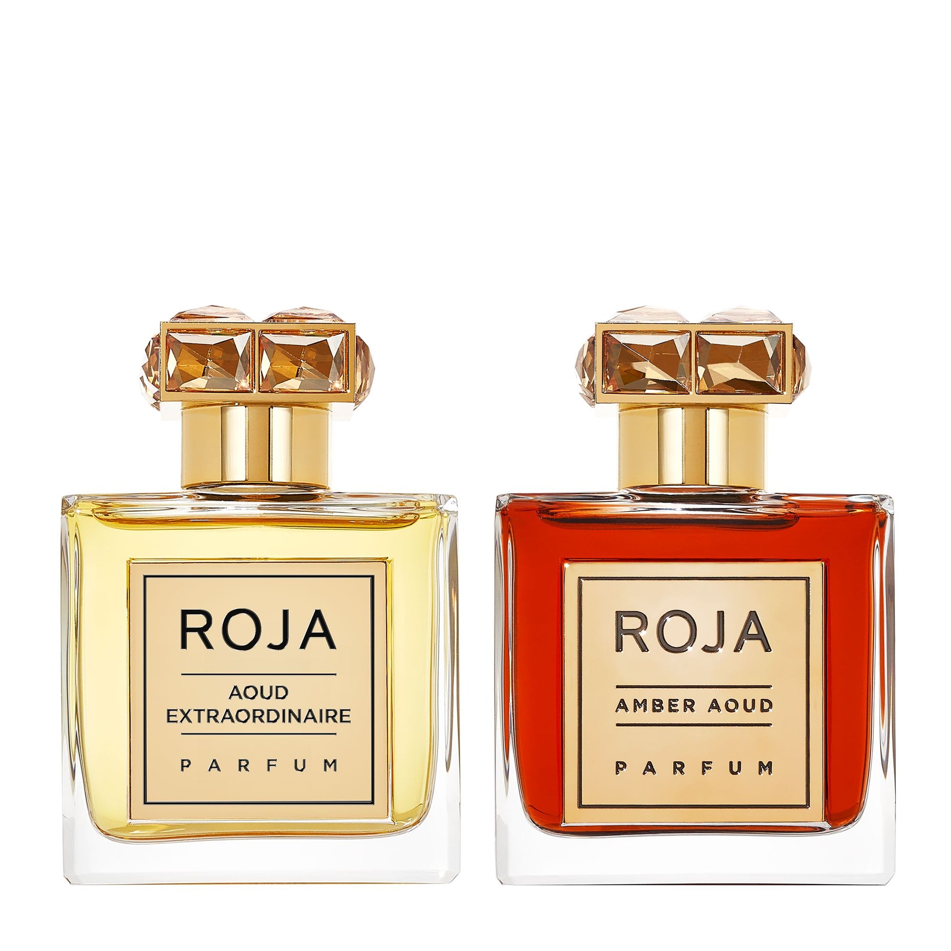 Two Roja Parfums bottles with gold caps: the left holds Roja Aoud Extraordinaire Parfum; the right, from The Aoud Layering Gift Set, contains the dark amber, oud-rich Roja Amber Aoud Parfum.