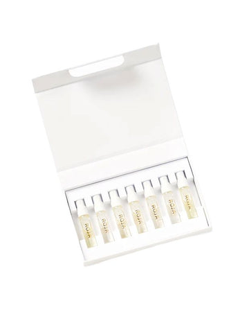 An open white box containing eight small transparent vials labeled ROJA with clear liquid inside, neatly arranged in a single row against a plain white background—this Signature Discovery Collection by Roja Parfums embodies olfactive art at its finest.